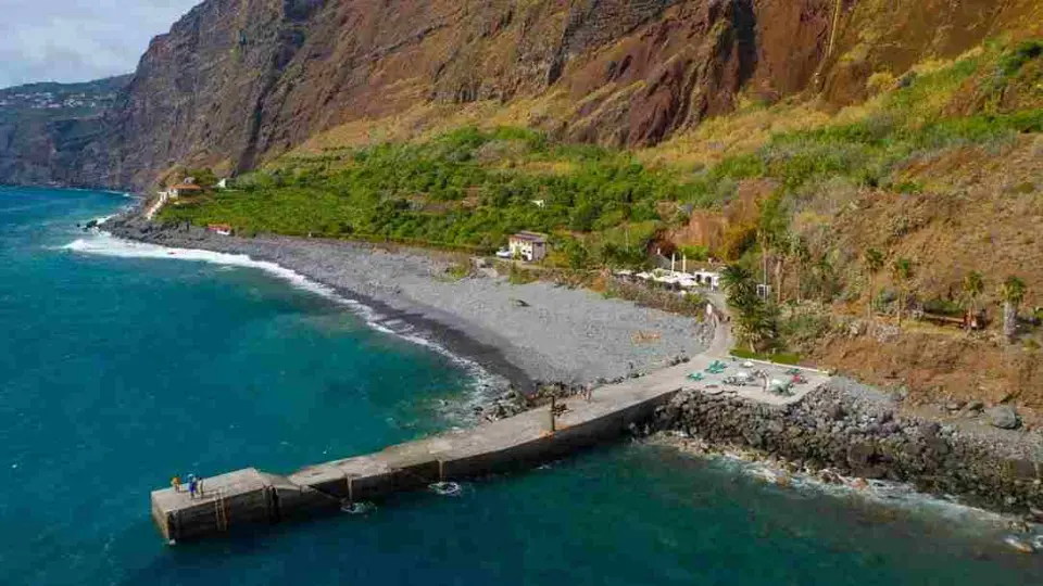 Fajã dos Padres pebble beach and pier at the foot of high sea cliffs