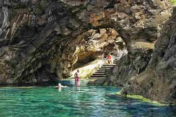 Black volcanic sand beach at Seixal under green cliffs